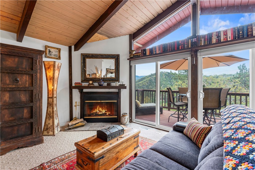 705 Cypress Road Cedar Glen, CA 92321 - Photo 14 of 51 a living room with furniture a floor to ceiling window and a fireplace