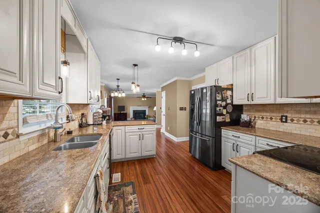 a kitchen with granite countertop a refrigerator stove top oven and sink