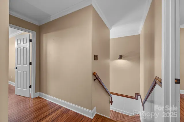 a view of a hallway with wooden floor and stairs
