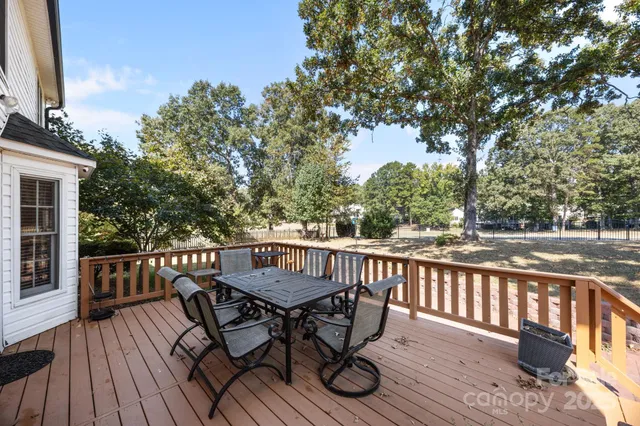 a view of a deck with furniture and trees around