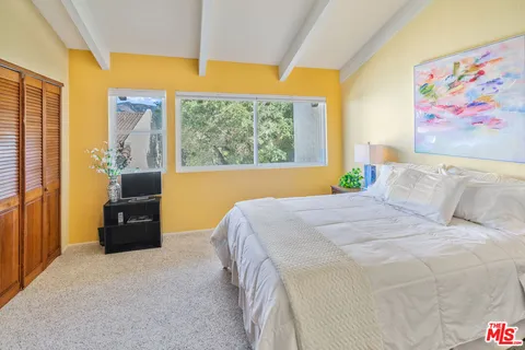 a bedroom with a bed and a painting on the wall