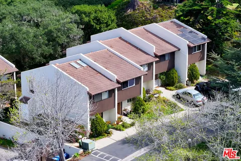 a aerial view of a house with a yard and potted plants