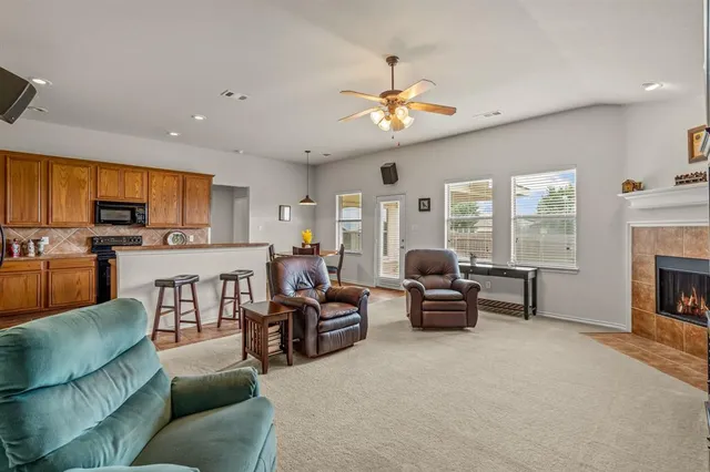 a living room with furniture fireplace and a large window