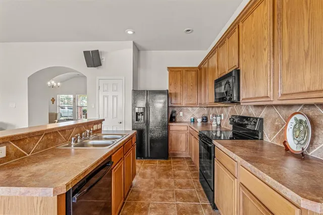 a kitchen with stainless steel appliances granite countertop a sink a stove and cabinets