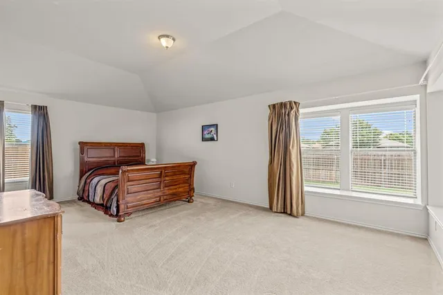 a spacious bedroom with a bed and wooden floor