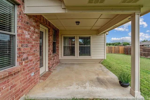 a view of a porch with a table and chairs and potted plants