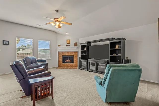 a living room with furniture a flat screen tv and a fireplace