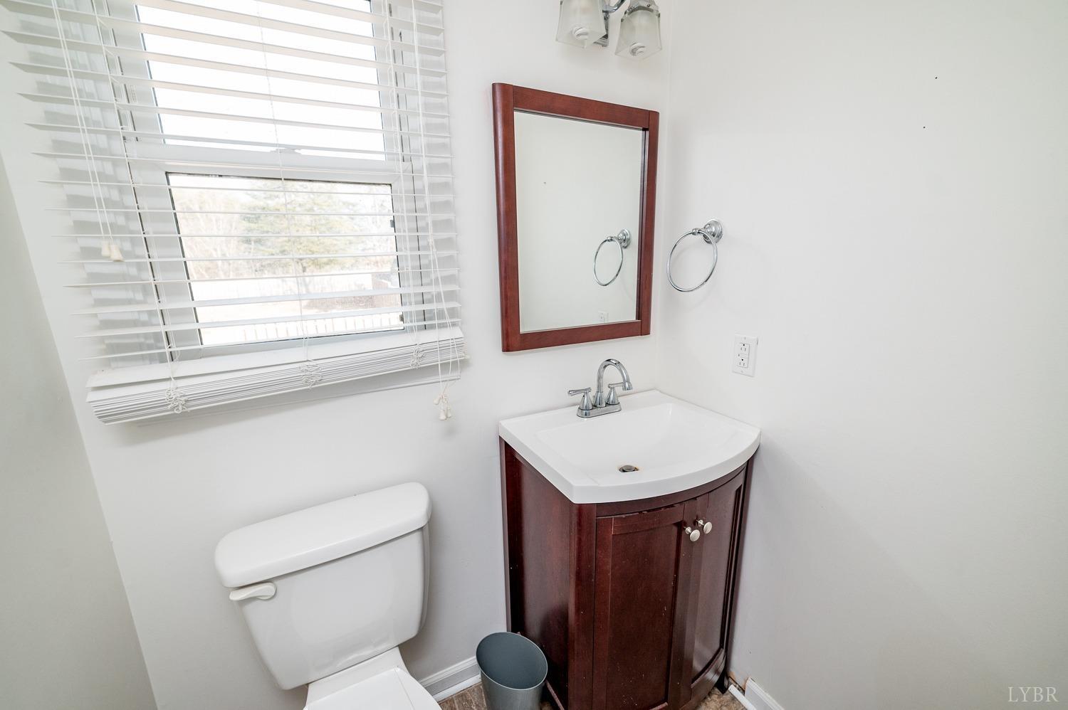 2271 Sunburst Road Evington, VA 24550 - Photo 14 of 26 a bathroom with a toilet sink and mirror
