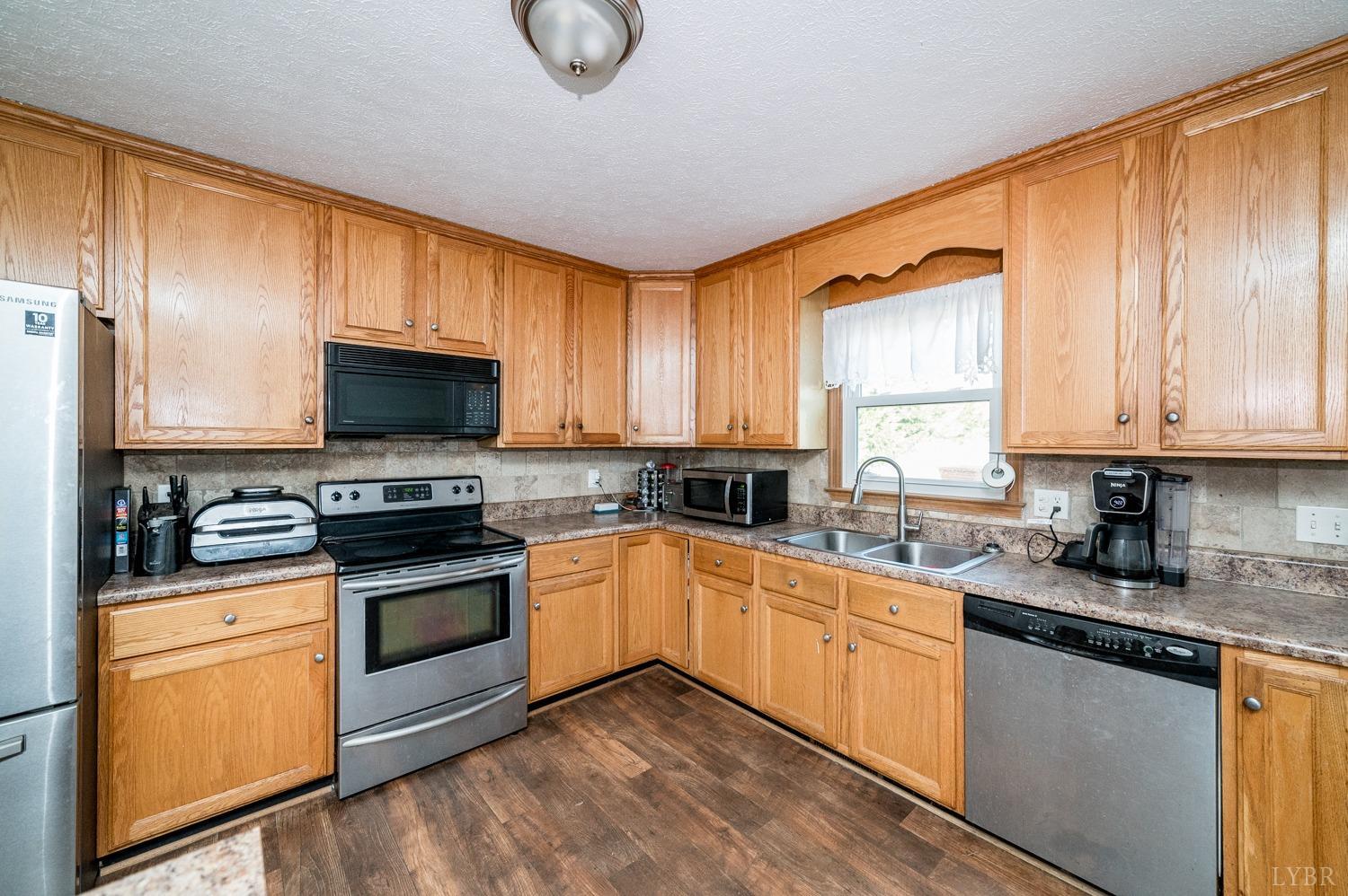 2271 Sunburst Road Evington, VA 24550 - Photo 5 of 26 a kitchen with granite countertop a sink cabinets stainless steel appliances and a window