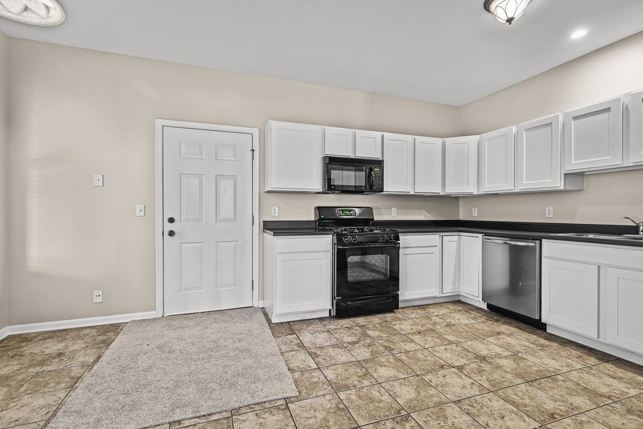 217 Market Street Genoa, IL 60135 - Photo 7 of 32 a kitchen with granite countertop a stove a sink and a refrigerator