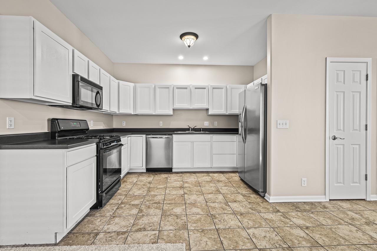 217 Market Street Genoa, IL 60135 - Photo 8 of 32 a kitchen with stainless steel appliances granite countertop a stove a sink and a refrigerator