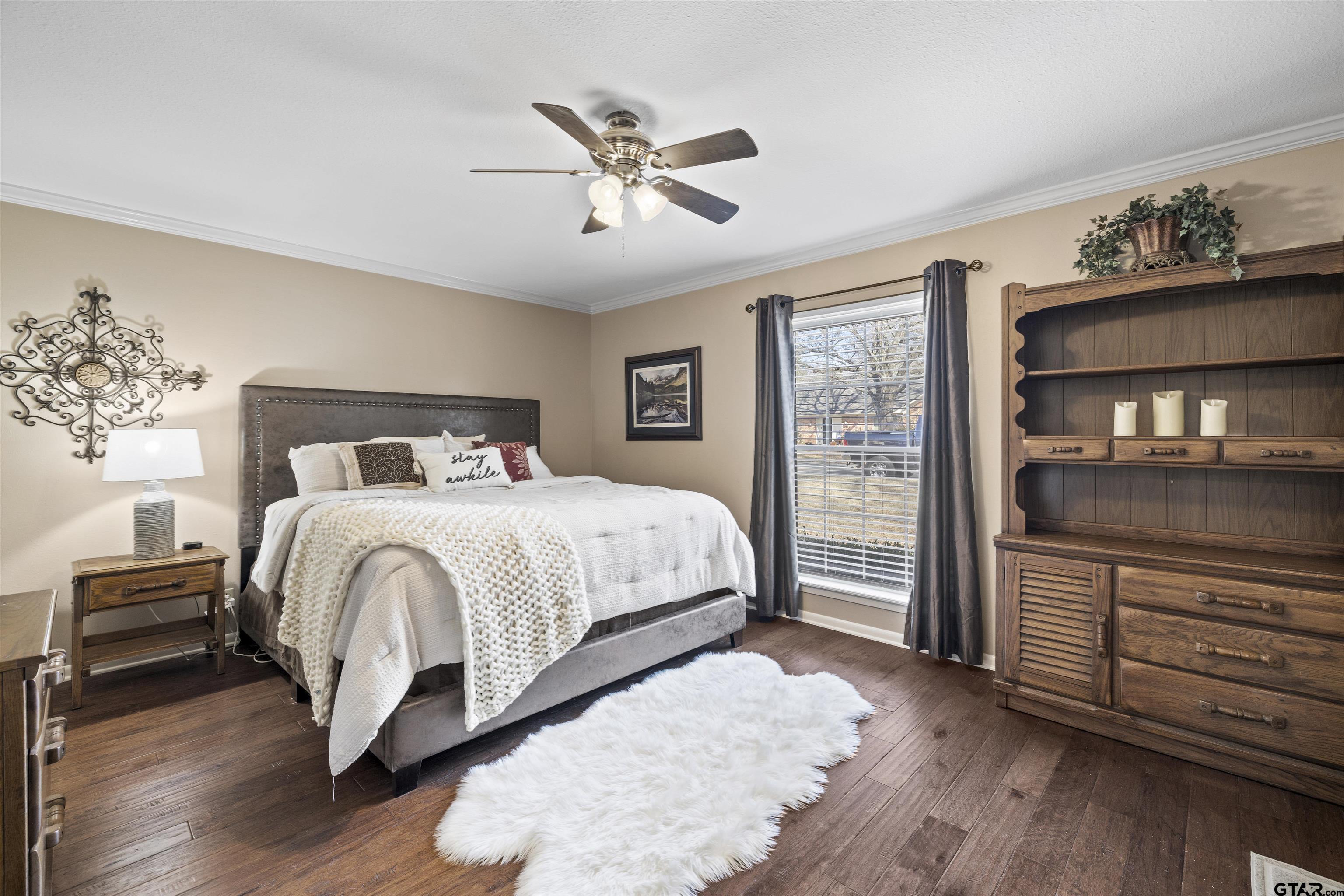 8235 Baylor Drive Tyler, TX 75703 - Photo 15 of 31 a spacious bedroom with a bed and a dresser with wooden floor