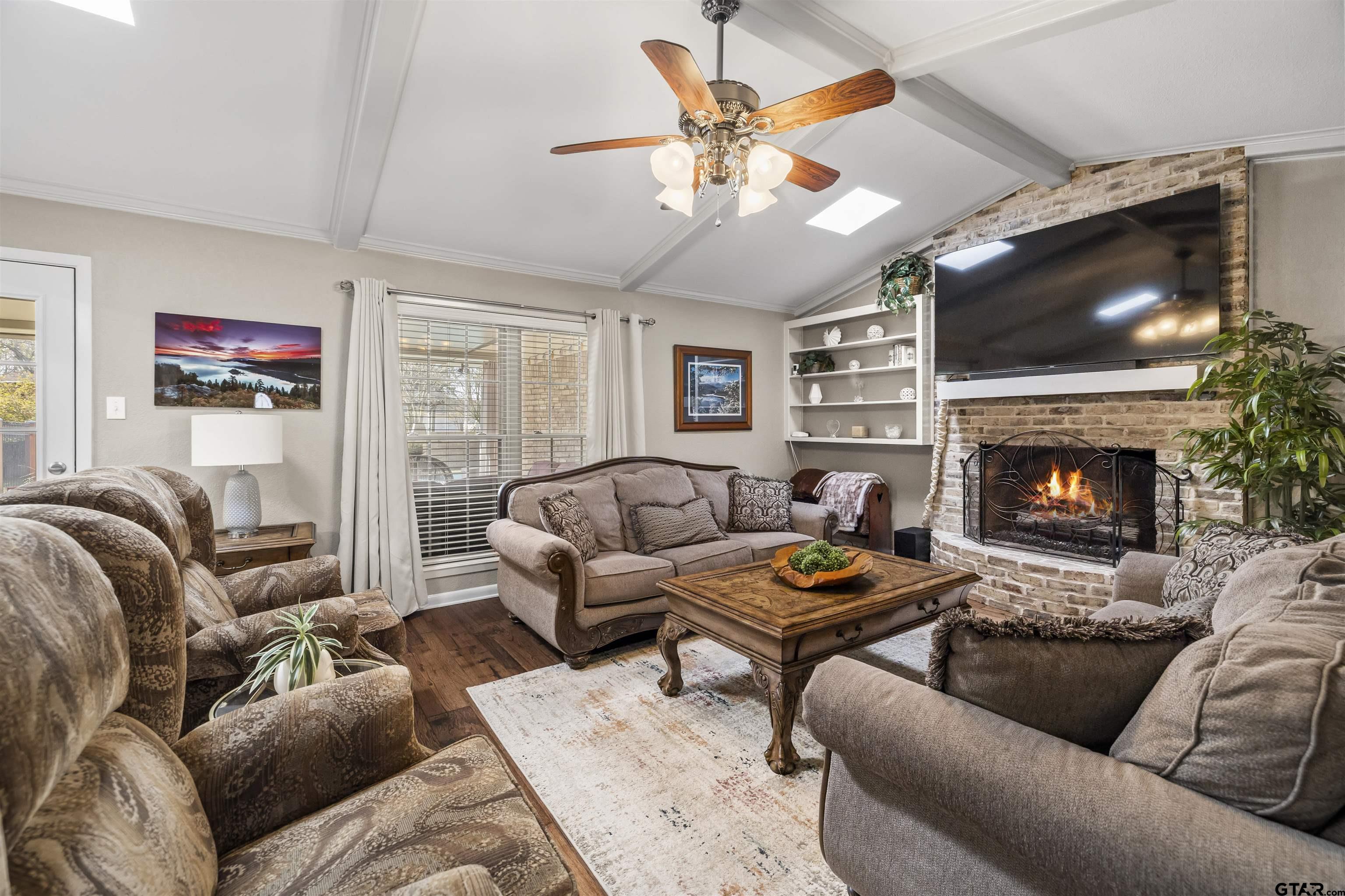 8235 Baylor Drive Tyler, TX 75703 - Photo 6 of 31 a living room with furniture a flat screen tv and a fireplace