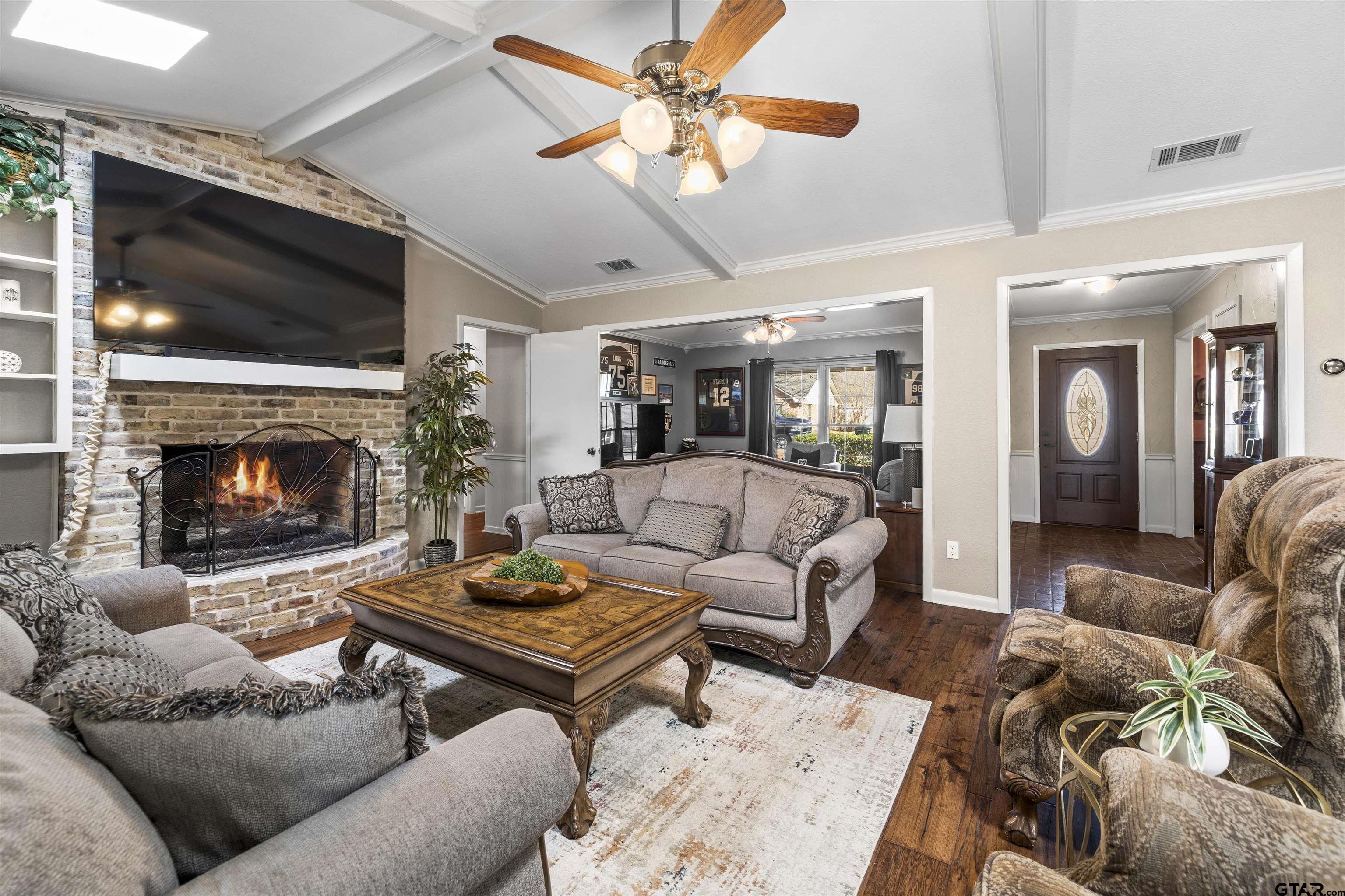 8235 Baylor Drive Tyler, TX 75703 - Photo 7 of 31 a living room with furniture a flat screen tv and a fireplace