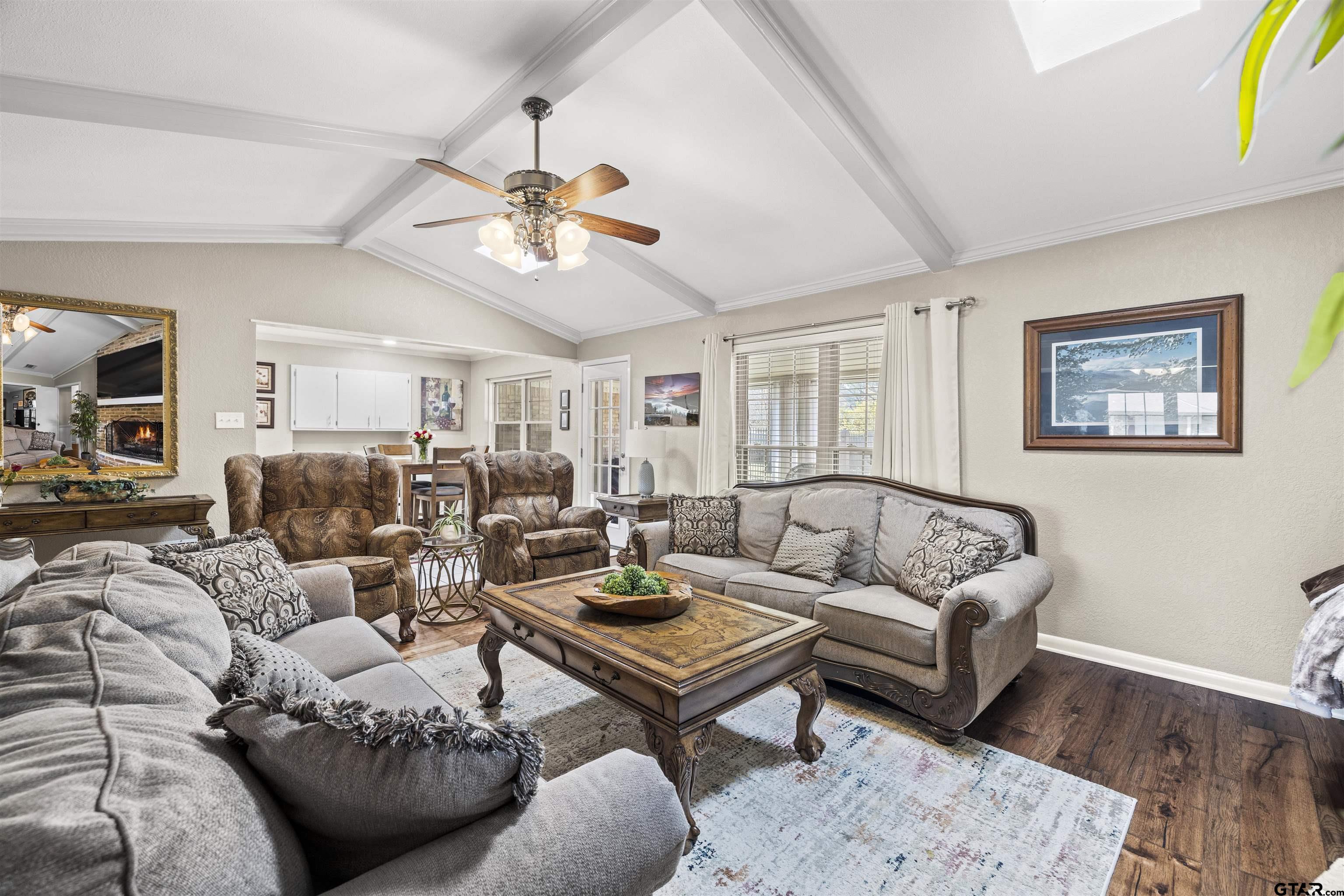 8235 Baylor Drive Tyler, TX 75703 - Photo 8 of 31 a living room with furniture a rug and a chandelier