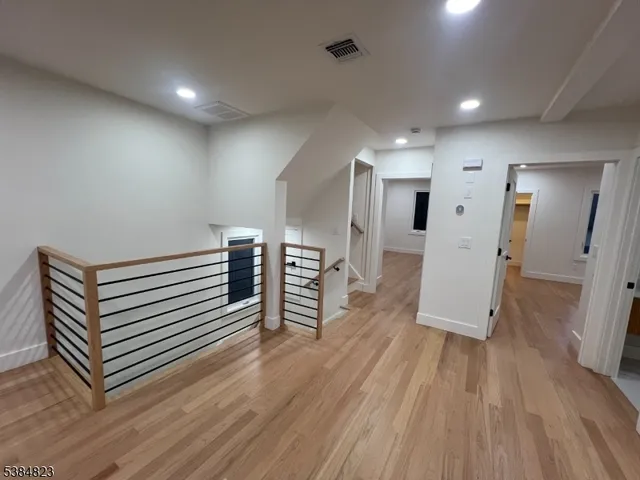 a view of a livingroom with wooden floor and staircase