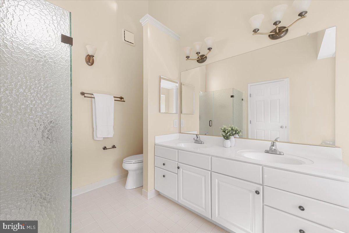 12664 Granite Ridge Drive North Potomac, MD 20878 - Photo 18 of 37 a bathroom with a double vanity sink toilet mirror and shower