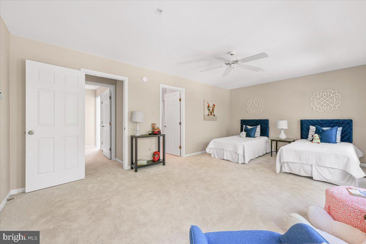 12664 Granite Ridge Drive North Potomac, MD 20878 - Photo 21 of 37 a spacious bedroom with two bed and a chandelier