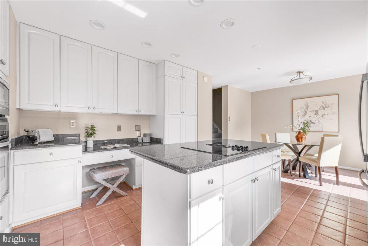 12664 Granite Ridge Drive North Potomac, MD 20878 - Photo 10 of 37 a kitchen with a stove a sink a dining table and chairs