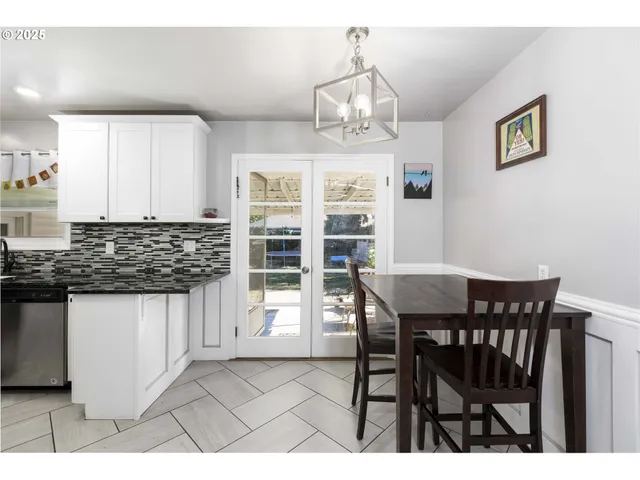 a kitchen with stainless steel appliances kitchen island granite countertop a refrigerator a stove a sink dishwasher and white cabinets with wooden floor