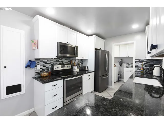 a kitchen with stainless steel appliances kitchen island granite countertop a sink and cabinets