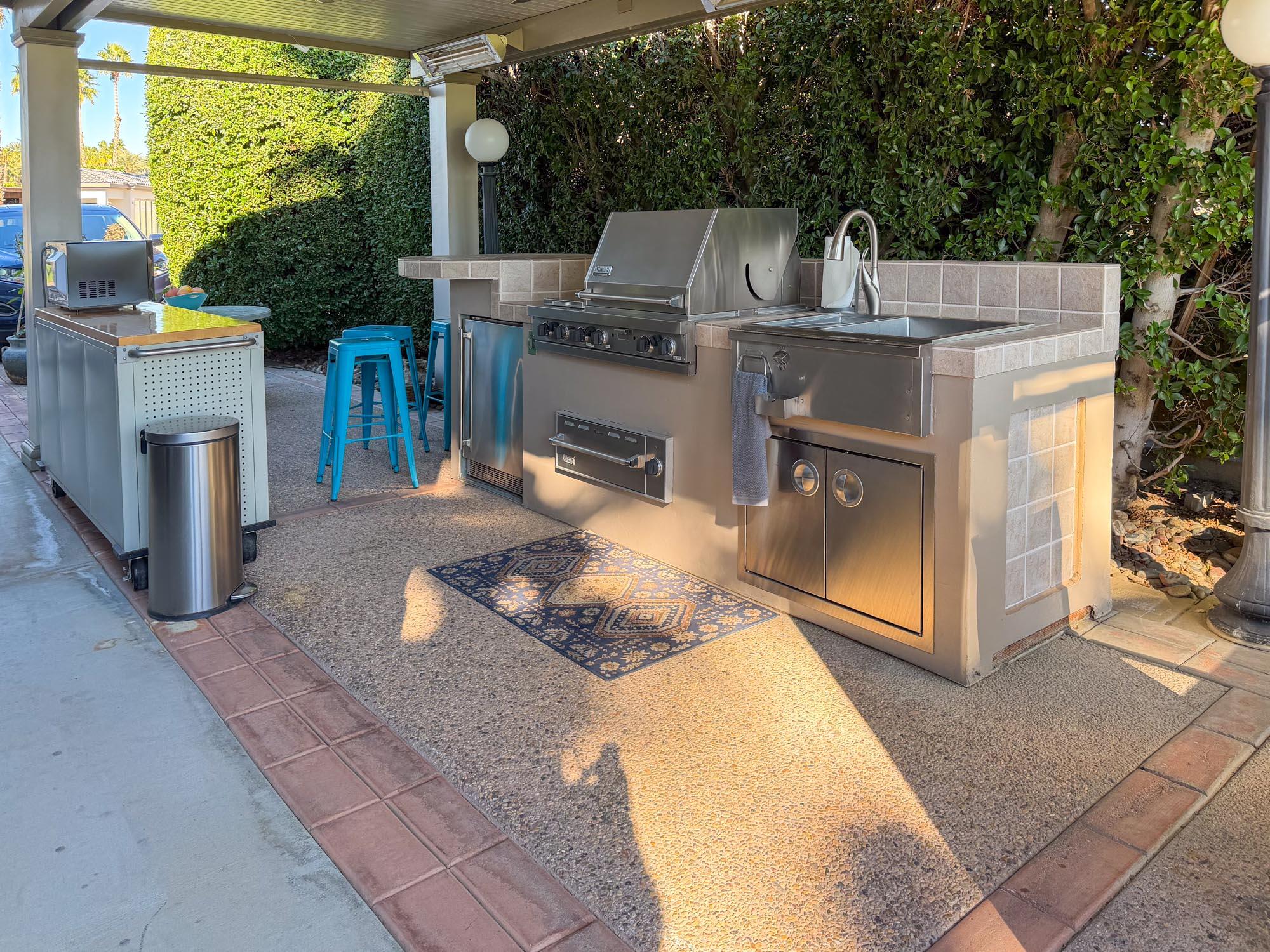 80394 Ave 48, Unit 220 Indio, CA 92201 - Photo 10 of 24 a view of a patio with table and chairs a barbeque grill with a small yard and large trees