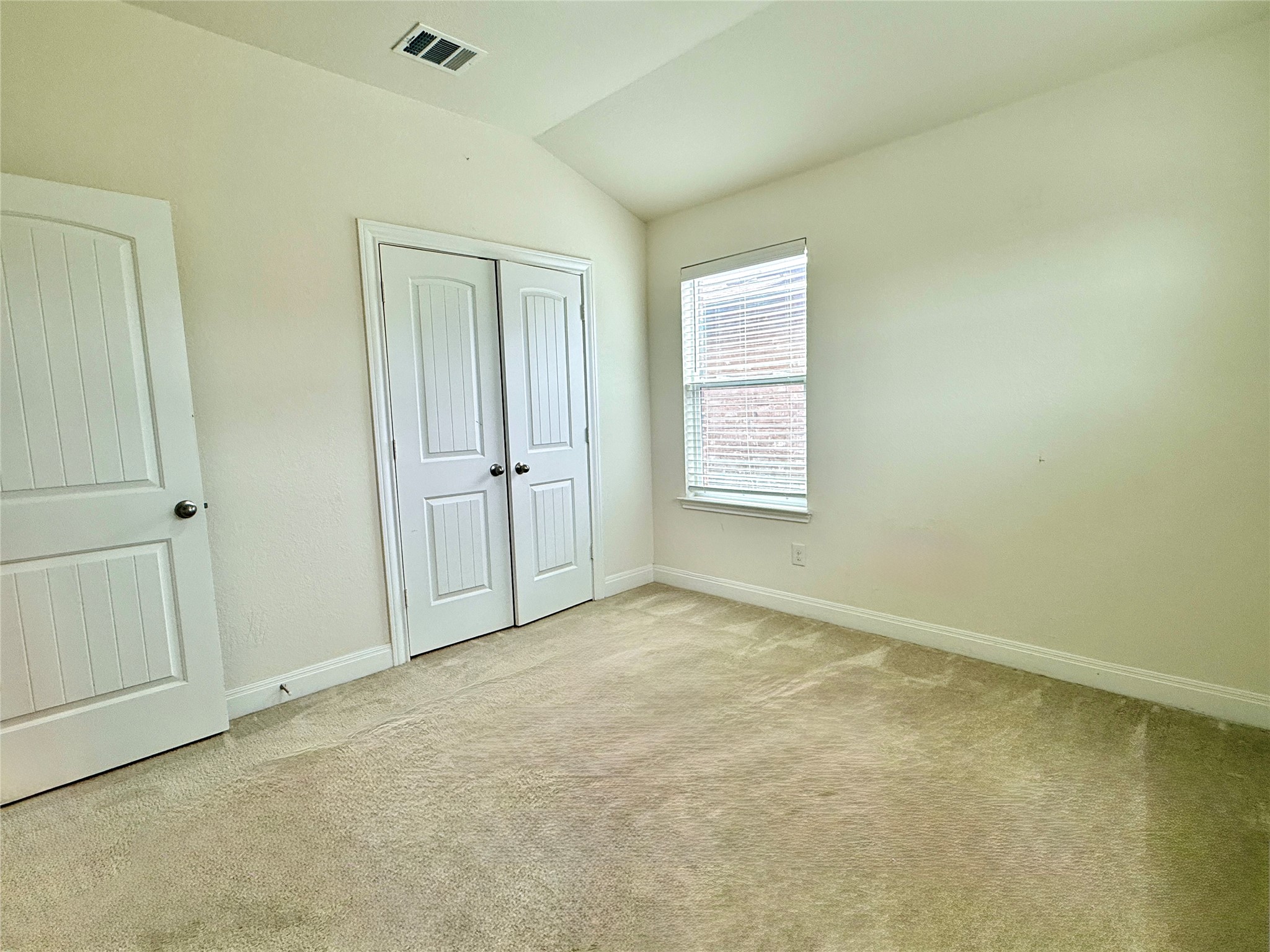 2101 Split Diamond Way, Unit 40 Round Rock, TX 78664 - Photo 29 of 32 A well-lit secondary bedroom provides ample space and a cozy atmosphere with carpeted floors.