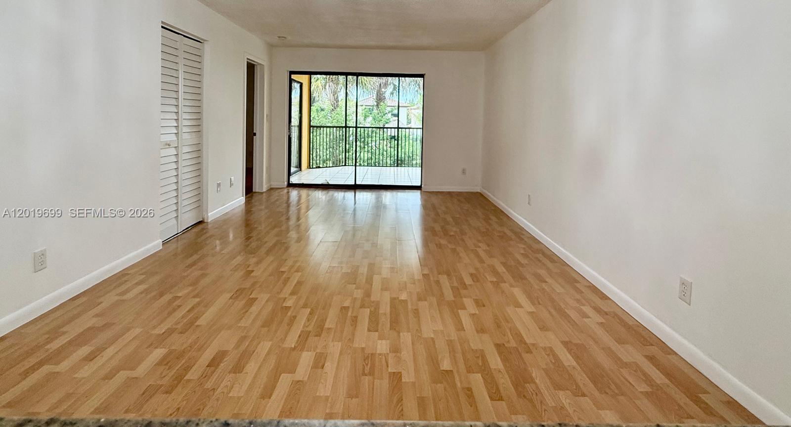 3470 Foxcroft Road, Unit 204 Miramar, FL 33025 - Photo 7 of 40 a view of an empty room with wooden floor and a window