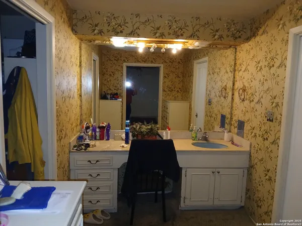 a bathroom with a sink vanity and a mirror