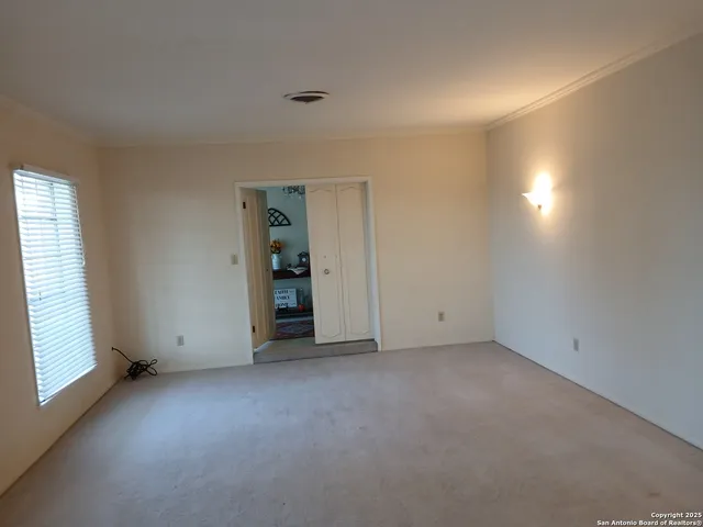 an empty room with closet and windows