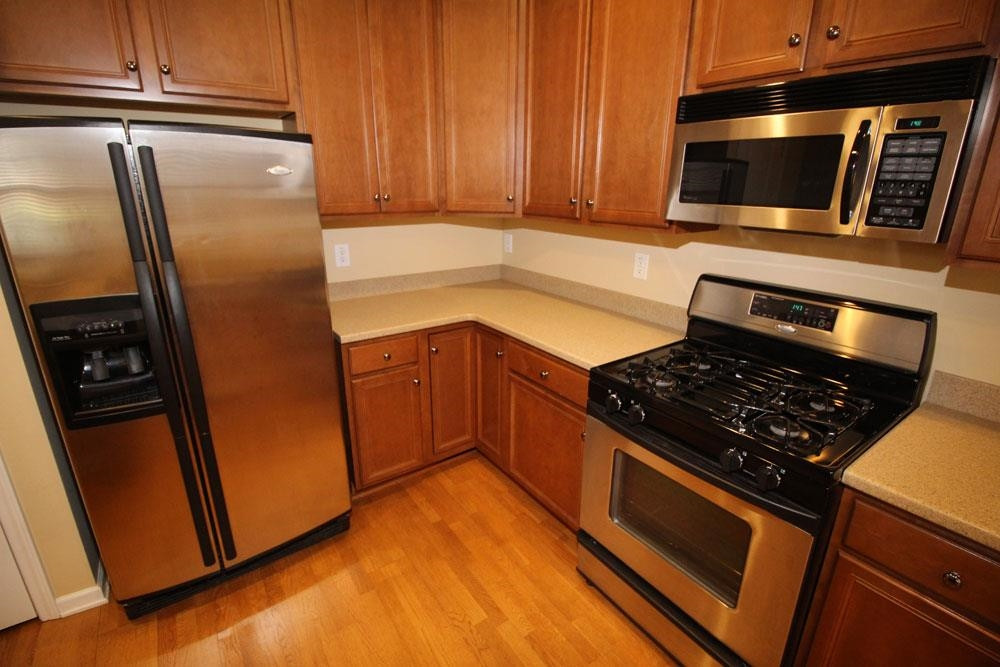 6952 Middleboro Drive Raleigh, NC 27612 - Photo 7 of 32 Kitchen features gas stove, 42” cabinets, solid surface counters & stainless steel appliances. Ktichen
