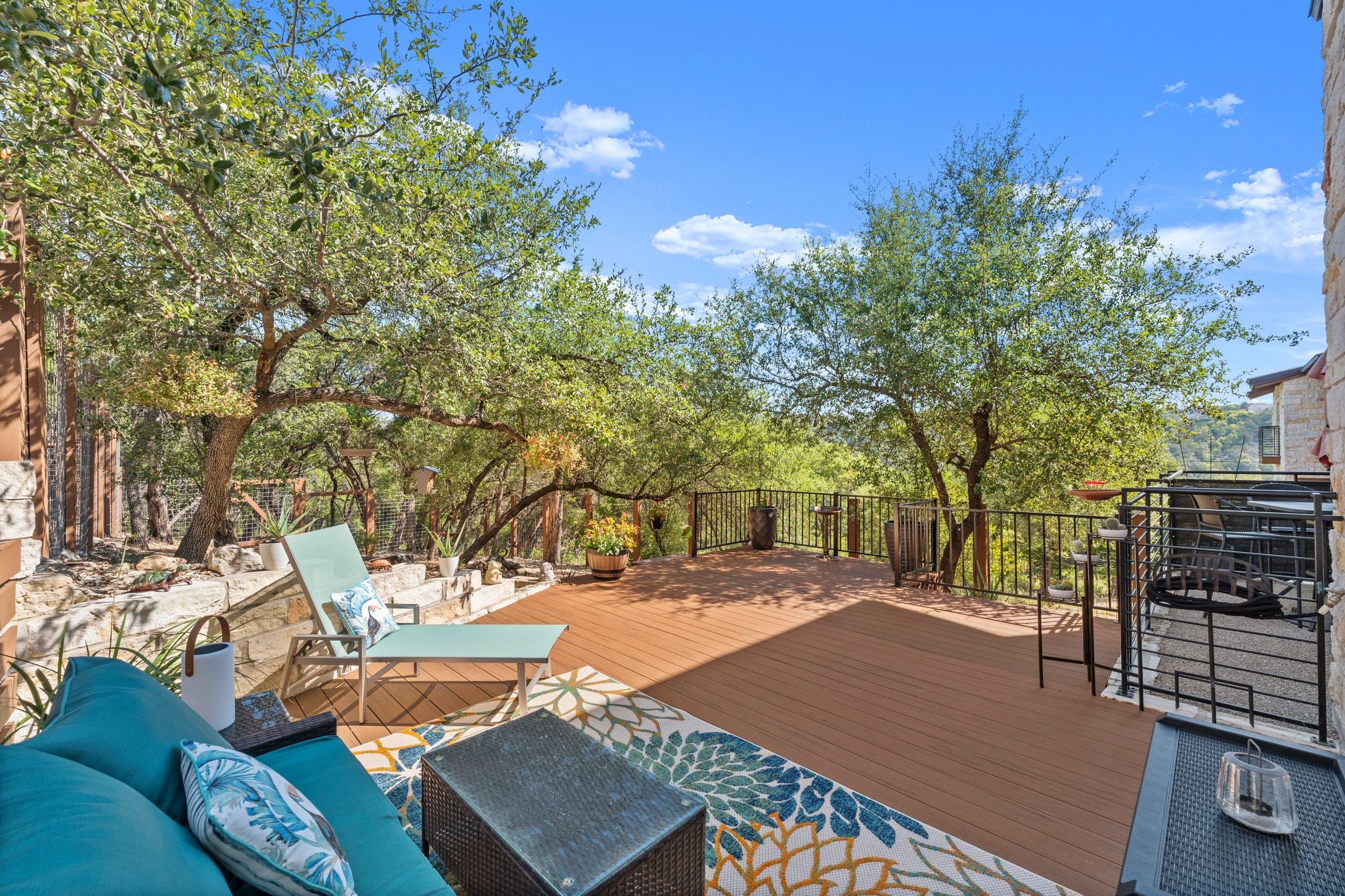 8110 Ranch Road 2222, Unit 92 Austin, TX 78730 - Photo 31 of 40 Expansive outdoor deck featuring wood-finish decking, mature trees, and a black wrought-iron railing