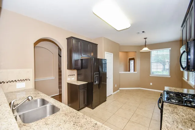 a kitchen with a refrigerator sink and cabinets