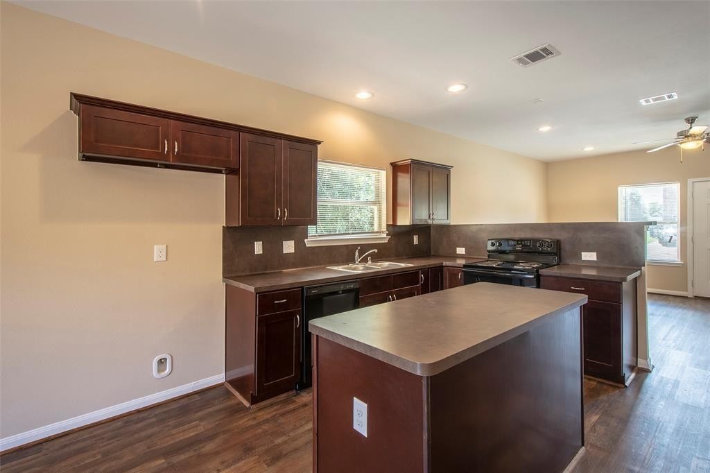 8142 Cabot Street, Unit A Houston, TX 77078 - Photo 3 of 21 a kitchen with a sink a stove a refrigerator and a microwave