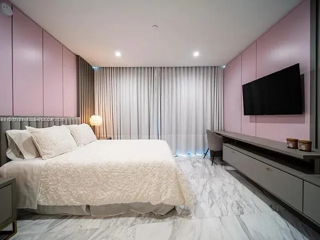 a spacious bedroom with a bed and a flat screen tv