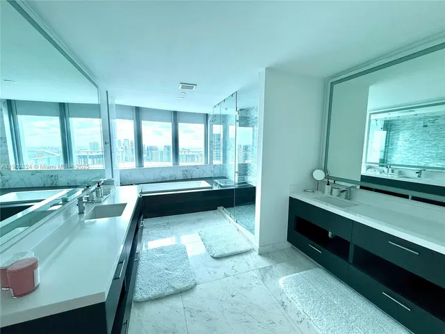 a bathroom with a tub sink and mirror