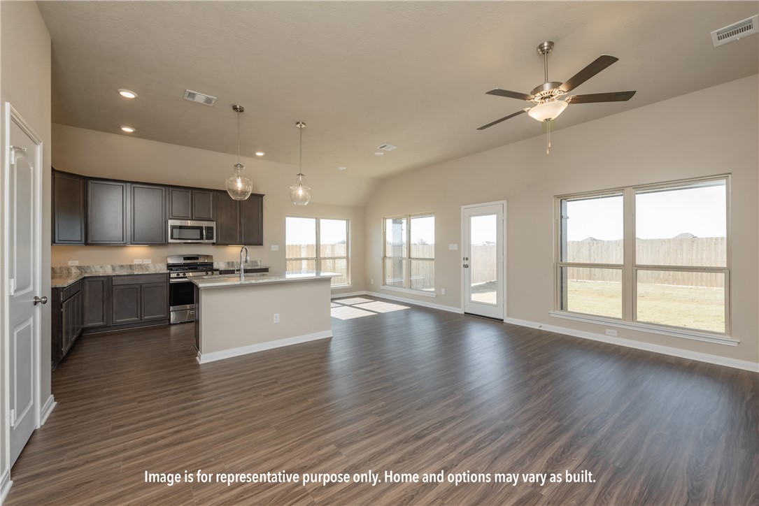 1901 Sebright Drive Bryan, TX 77807 - Photo 9 of 9 a view of an empty room with wooden floor and a kitchen