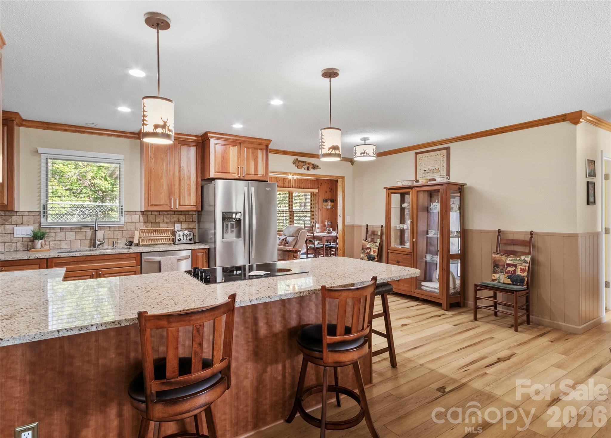 342 Mountain View Road Burnsville, NC 28714 - Photo 12 of 46 a kitchen with stainless steel appliances kitchen island granite countertop a dining table chairs and a refrigerator