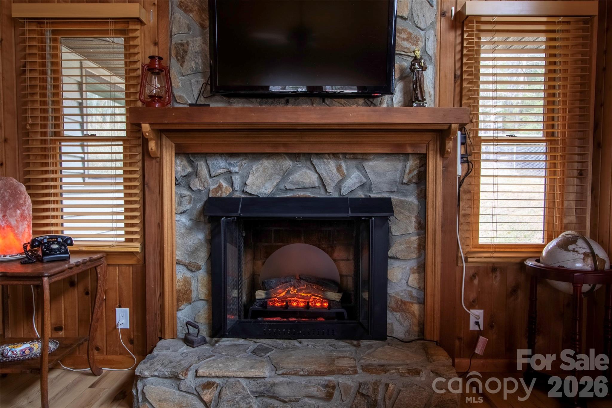 342 Mountain View Road Burnsville, NC 28714 - Photo 19 of 46 a living room with a fireplace a flat screen tv and a window