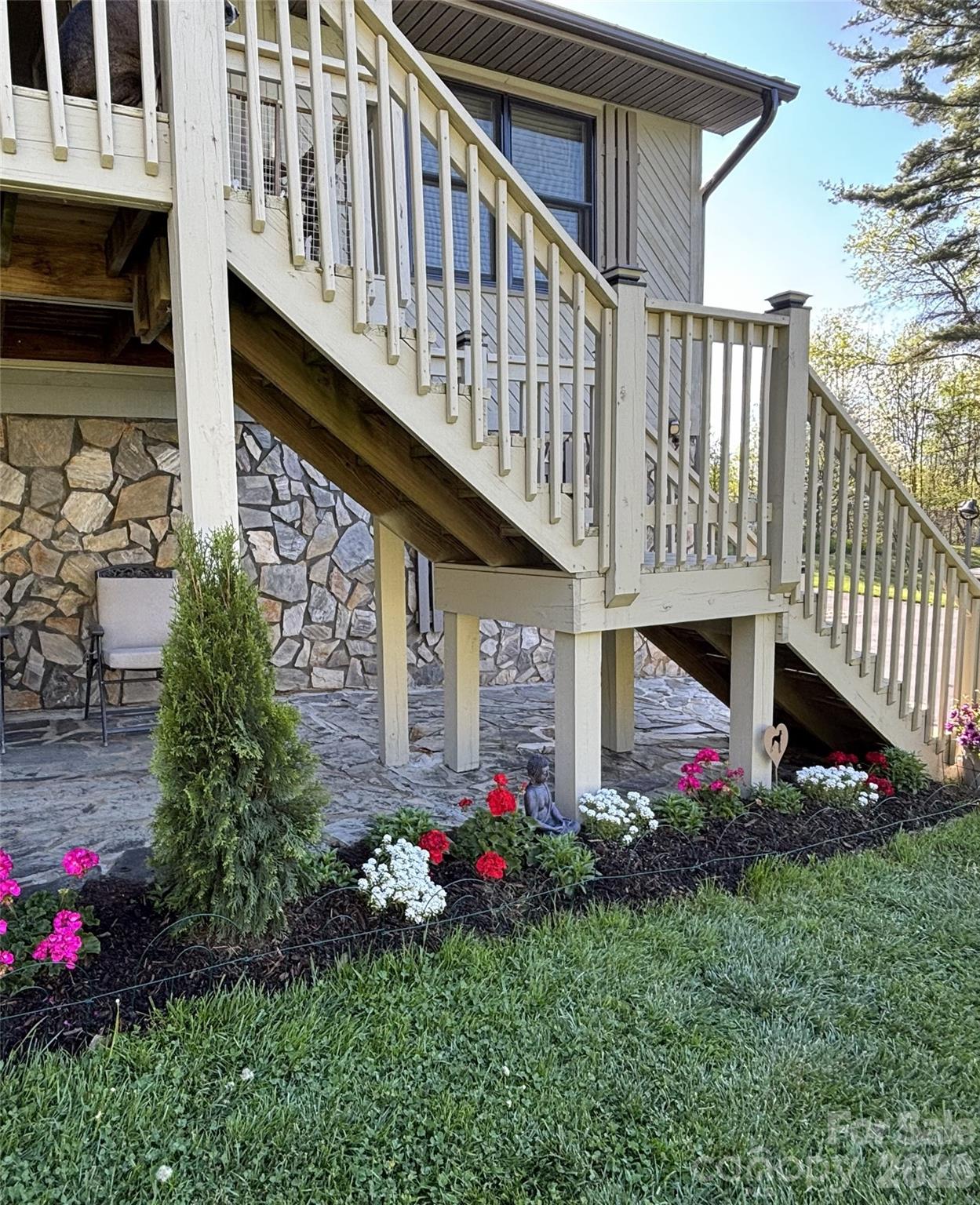 342 Mountain View Road Burnsville, NC 28714 - Photo 4 of 46 a view of a house with brick walls and a flower garden in front of main door