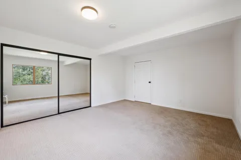 a bedroom with a bed couch and a large window