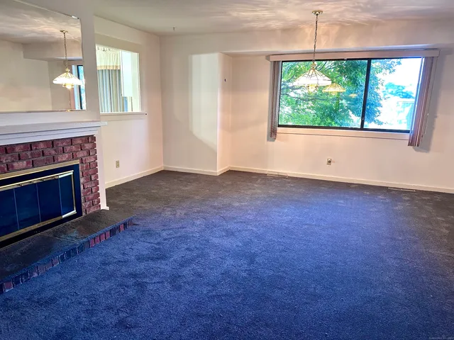 an empty room with windows and fireplace