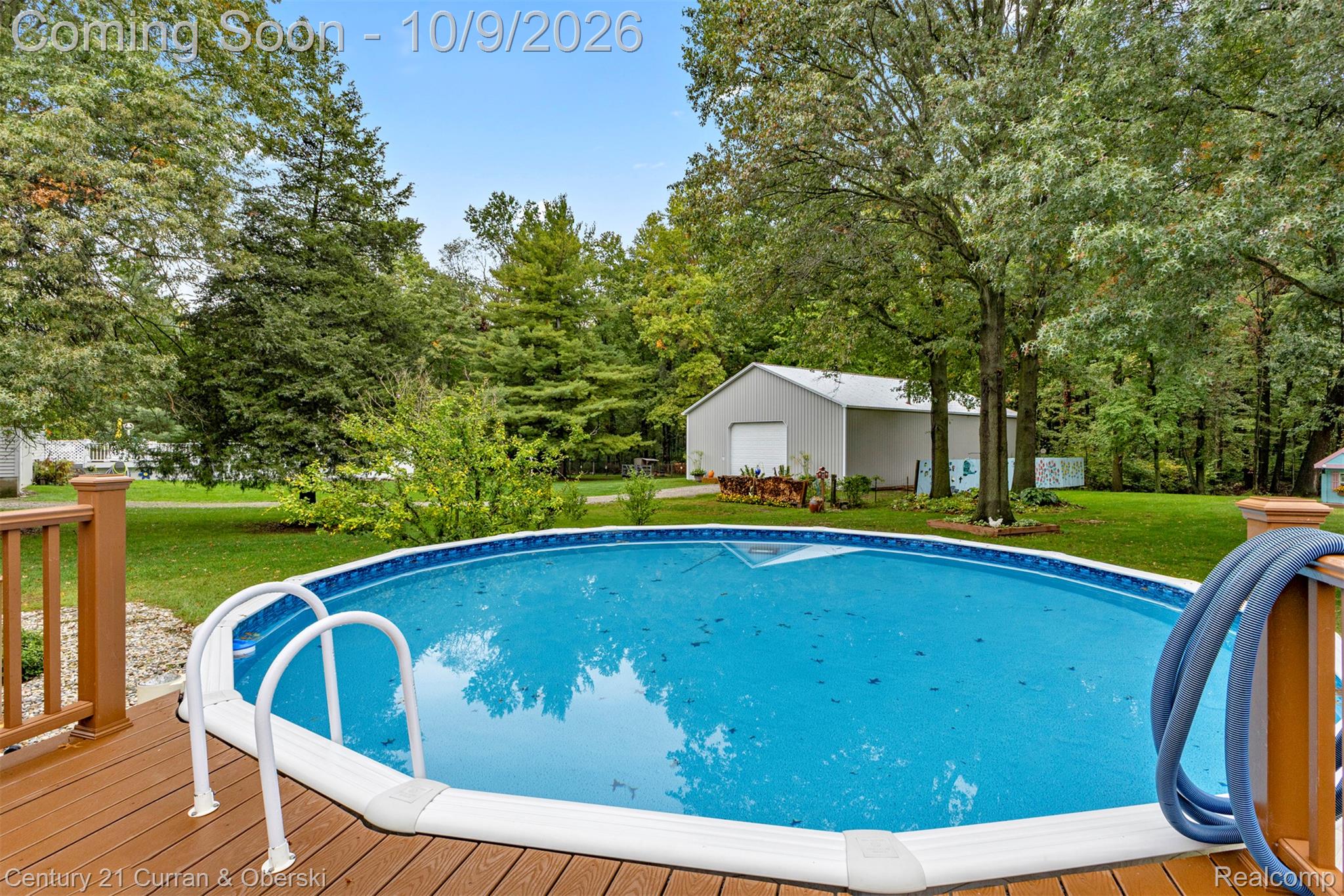 43040 Willis Road Belleville, MI 48111 - Photo 48 of 65 Above-ground pool with access ladder, wood-finish deck, and expansive green lawn