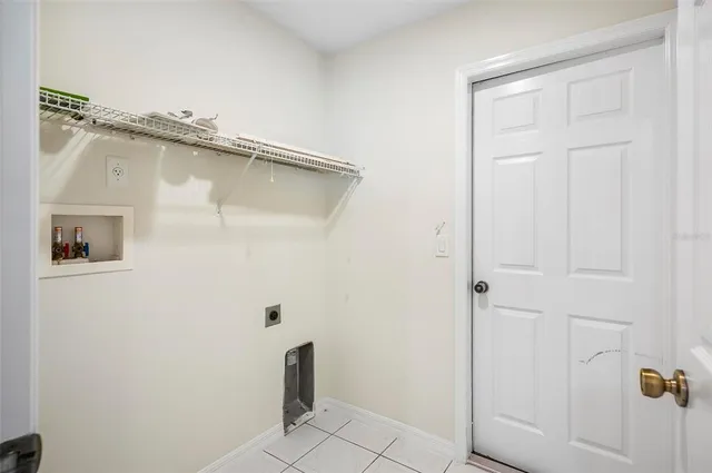 an empty room with a chandelier fan and windows