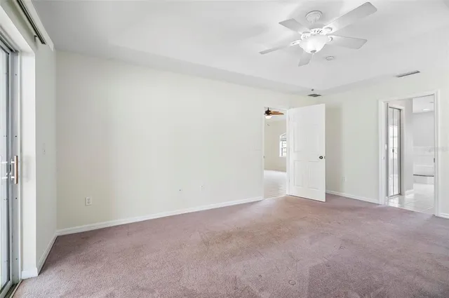 an empty room with a window and a fan
