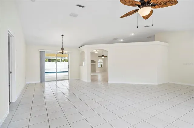 a view of a livingroom with a chandelier fan and windows