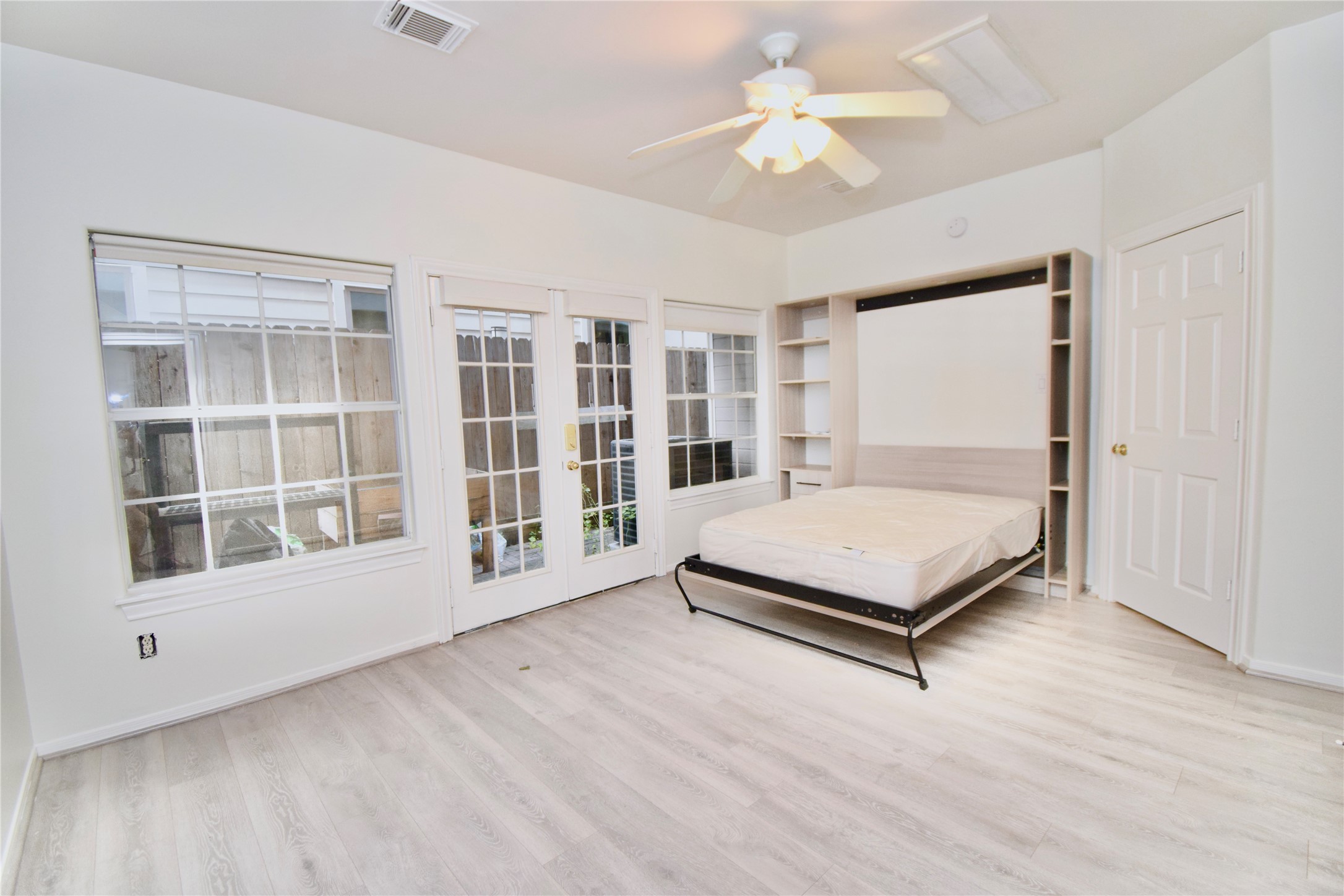 2024 Welch Street Houston, TX 77019 - Photo 11 of 18 a bedroom with a bed and a large window with garden view