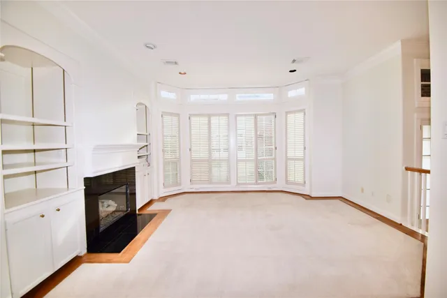 a view of an empty room with a fireplace and a window