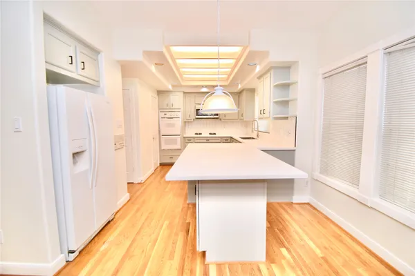 a kitchen with kitchen island a sink cabinets and wooden floor