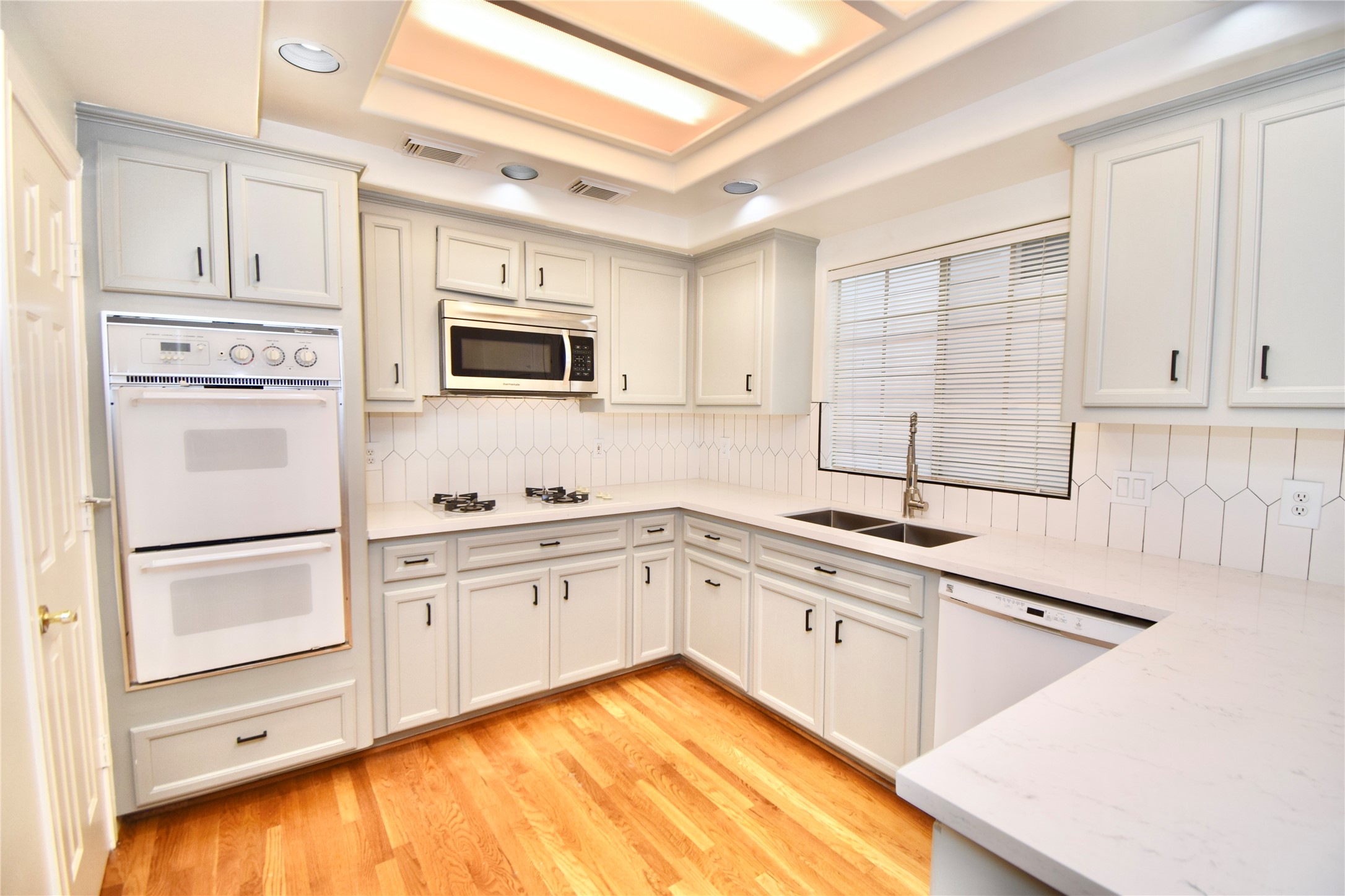 2024 Welch Street Houston, TX 77019 - Photo 5 of 18 a kitchen with granite countertop white cabinets and white appliances